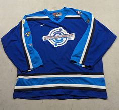 a blue hockey jersey sitting on top of a white floor