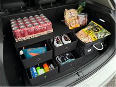 an open trunk with drinks, snacks and other items in the back seat for storage