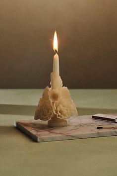 a lit candle sitting on top of a marble slab