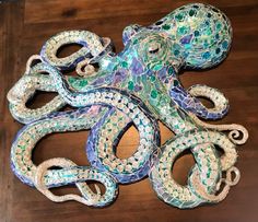 an octopus sculpture made out of glass on top of a wooden table