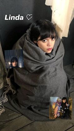 a woman wrapped in a blanket sitting on the floor