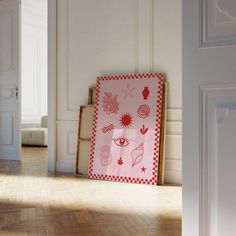 an empty room with white walls and wooden flooring has a pink framed artwork on the wall