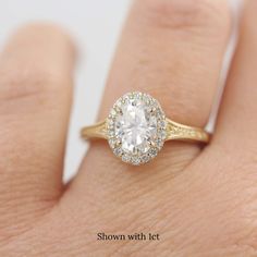 a woman's hand with a diamond ring on top of her finger, showing the center stone