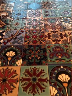 the floor is covered with colorful tiles and designs on it's sides, all in different colors