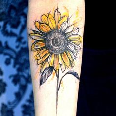 a yellow sunflower tattoo on the arm