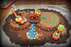 a birthday cake that is made to look like a construction site with cars and trucks on it