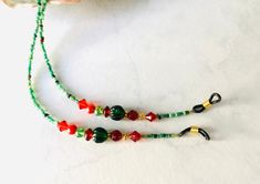 "Handmade eyeglass holder with a holiday feel with red and green glass beads, red crystal beads, silver toned spacers, and green seed beads.  The chain is 26 1/2\" long and should fit most eyeglasses or sunglasses." Red Glass Glasses Chains For Gift, Red Glass Glasses Chains As A Gift, Adjustable Green Glasses Chain For Gift, Adjustable Green Glasses Chains For Gifts, Green Round Beaded Glasses Chains For Gifts, Green Adjustable Glasses Chain As A Gift, Red Beaded Glasses Chains As Gift, Green Adjustable Chain Glasses Chains As Gift, Red Beaded Glasses Chains For Gift