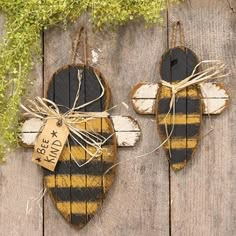 two bees are hanging on the side of a wooden fence