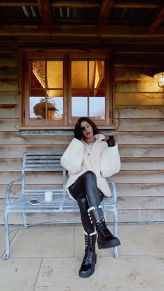 a woman sitting on a bench in front of a building