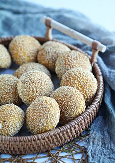 a basket filled with sesame sprinkles on top of a blue cloth next to a knife