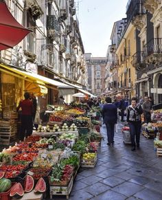 an outdoor market with lots of fruits and vegetables