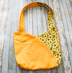 a sunflower print bag sitting on top of a wooden floor