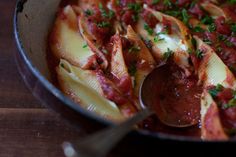 a skillet filled with pasta and meat covered in sauce