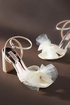 the brides shoes are decorated with white tulle and bows on their heels,