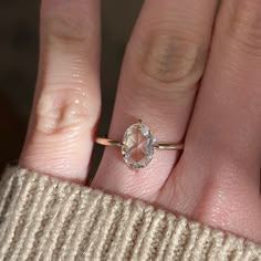 a woman's hand with a diamond ring on top of her finger, showing the size