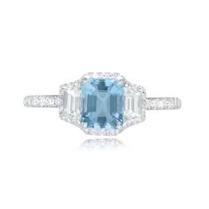 An aquamarine and diamond ring featuring a 0.71 carat emerald-cut aquamarine, set in prongs. The aquamarine is flanked by two trapezoid cut diamonds with a combined weight of 0.39 carats. Micro-pave round brilliant cut diamonds are set around the border of the mounting and along the shoulders. The combined weight of the round brilliant cut diamonds is 0.31 carats. This ring is handcrafted in platinum.
The measurements of the aquamarine are approximately 5.98mm x 4.92mm x 3.44mm.
This ring can be Bezel Set Diamond Ring, Estate Diamond Jewelry, Bezel Set Diamond, Aquamarine Stone, Perfect Engagement Ring, Micro Pave, Unique Engagement Rings, Three Stone, Round Brilliant Cut Diamond