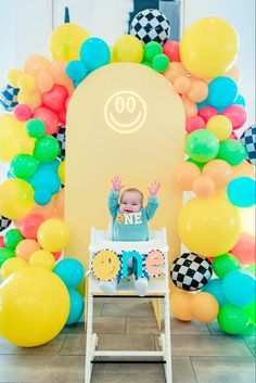 a baby sitting in a highchair with balloons around it and a sign that says 90