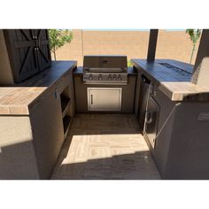 an outdoor kitchen with stove, sink and refrigerator