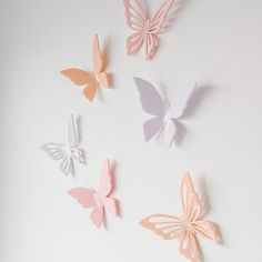 the wall is decorated with pastel butterflies on white paper, and there are also small ones in different colors