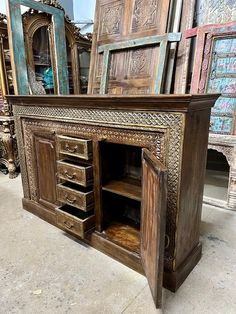 an ornate wooden cabinet with drawers and mirrors in the background, surrounded by other antique furniture