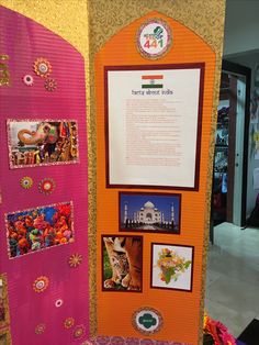 a display with pictures and information on it in a room filled with other items, including an orange door