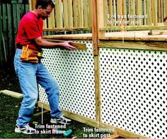 a man standing next to a wooden fence