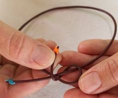 a person holding a string with two small beads on it