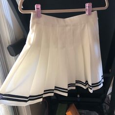 White Pleated Cheer Skirt With Navy Blue Strip. Size Medium Never Worn White Mini Skort For Day Out, White Mini Tennis Skirt For Day Out, White Mini Pleated Skort, White Mini Pleated Skirt For Spring, White Flared Tennis Skirt For Spring, White Pleated Flared Skort, Casual White Skirted Skort, White Flowy Lined Tennis Skirt, Casual White Mini Tennis Skirt