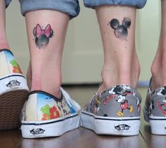 two people with mickey and minnie mouse tattoos on their feet, both wearing matching shoes