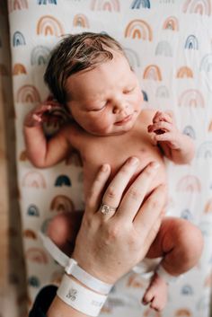 a woman holding a baby in her arms while wearing a band around it's wrist