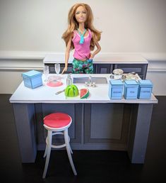 a barbie doll is standing in front of a kitchen counter with food and drinks on it