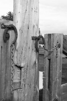 an old wooden gate with chains on it