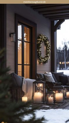 the front porch is decked out with candles and wreaths for holiday decorating