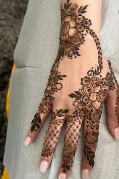 a woman's hand with henna tattoos on it