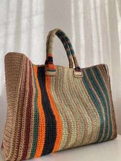 a multicolored bag sitting on top of a white table next to a window