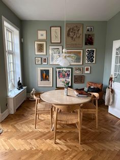 a dining room with wooden floors and pictures on the wall