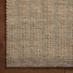 an area rug that is on top of a wooden floor with a brown and tan color scheme