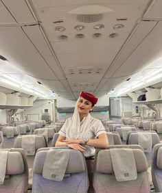 a woman is sitting on an airplane with her arms crossed and looking at the camera