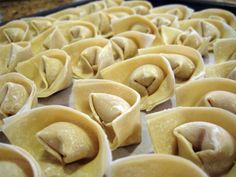 some dumplings are sitting on a baking sheet and ready to be cooked in the oven