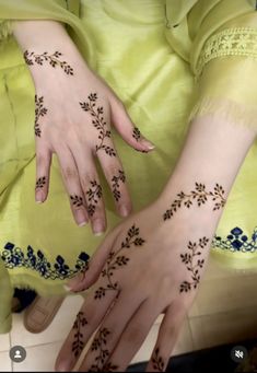 two hands with henna tattoos on them