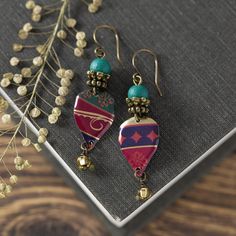 Looking for unique boho style jewelry? Don't miss out on these one-of-a-kind bohemian earrings! Carefully handcrafted from recycled vintage tins, these elegant earrings feature colorful patterns, adding a special touch. Lightweight and stylish, they are finished with glass beads and hypoallergenic antiqued brass ear wires. I take great care in crafting my vintage tin earrings, ensuring smooth edges through a meticulous sanding process. Given the vintage materials used, minor imperfections may be present, adding to their charm and uniqueness. These bohemian earrings measure about 2" long from the top of the wire to the bottom and are about 1/2" wide. Feel free to reach out if you have any questions at all. Thank you for visiting my shop, and be sure to check back often as I'm always creatin Bohemian Drop Earrings For Vintage Collection, Bohemian Vintage Drop Earrings, Retro Dangle Earrings For Festivals, Red Bohemian Soldered Earrings, Bohemian Red Soldered Earrings, Bohemian Patina Earrings For Gift, Bohemian Festival Earrings With Patina, Bohemian Patina Earrings Gift, Bohemian Patina Earrings