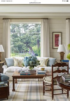 a living room filled with furniture next to a window covered in windowsills and curtains