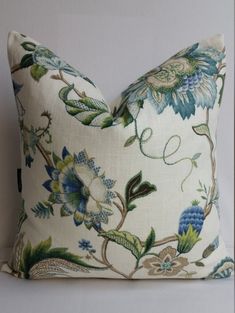 a white pillow with blue and green flowers on it