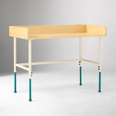 a wooden desk with blue legs and a white table top on the bottom, in front of a gray background