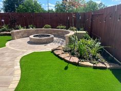 a backyard with artificial grass and a fire pit