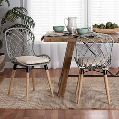 two chairs sitting at a table with plates and cups on it