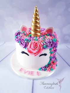 a cake decorated with flowers and a unicorn's head