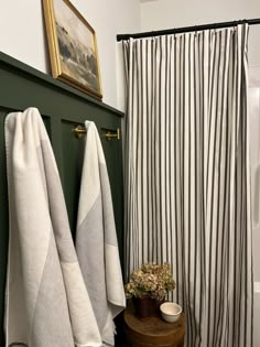 two towels are hanging on the wall next to a bathtub