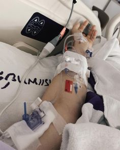 a person laying in a hospital bed with an iv