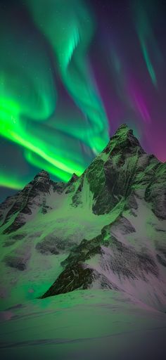 green and purple aurora lights in the sky above a snow covered mountain range at night